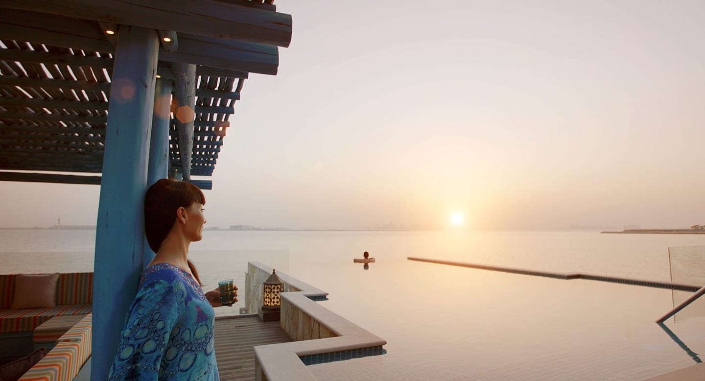 banana island doha anantara overwater villa sunset couple 01 1920x1037